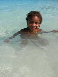A Pikinini swimming in the crystal clear water at Port Orly Beach